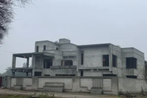 Under-construction residential building featuring raw concrete structure, multi-level layout, and architectural framework in early development phase for custom home construction.